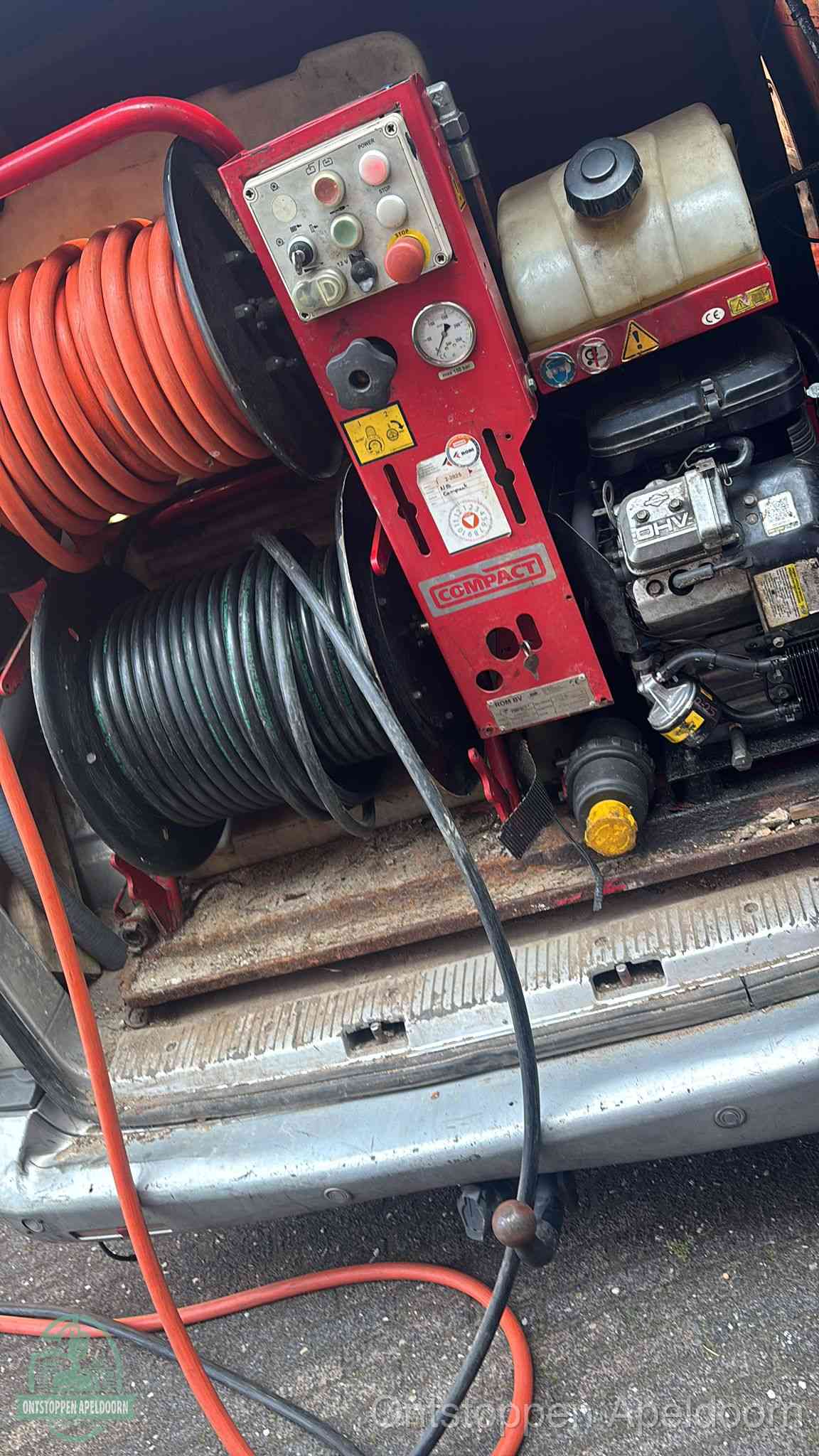 Een rood hogedruk-rioolreinigingstoestel in de laadbak van de bedrijfsbus, apparatuur voor een hardnekkige afvoerverstopping in Apeldoorn
