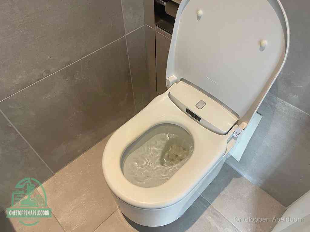 Een toiletpot vol troebel water met drijvend papier en restanten, de meest voorkomende oorzaak van een verstopte wc in Apeldoorn