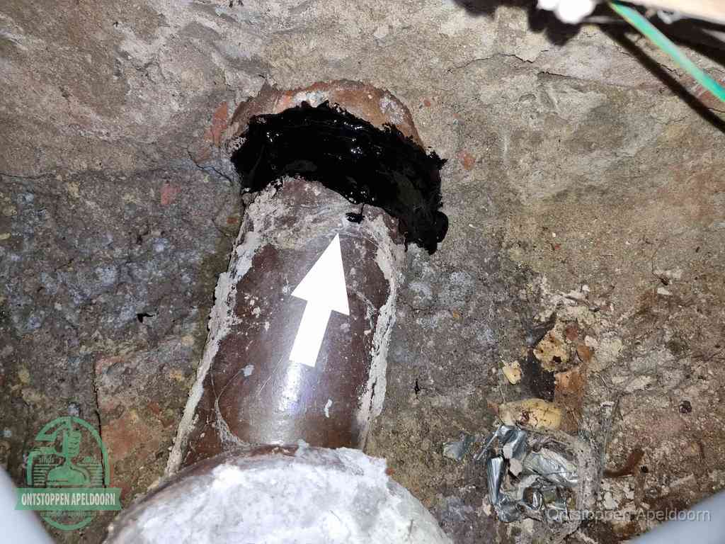 Een oude gres rioolbuis met een beschadigde koppeling onder de vloer, oorzaak van terugkerende structurele wc-problemen in Apeldoorn