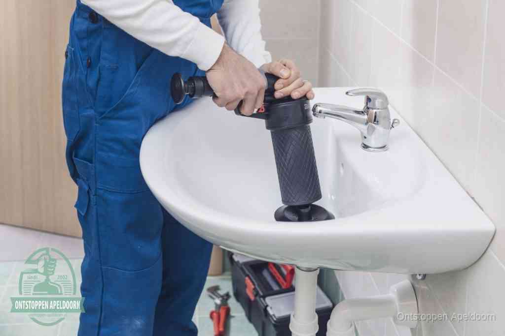 Een te ruwe doe-het-zelf poging met een hand-pomp op de afvoer van een badkamer-wastafel, een van de veelgemaakte fouten bij afvoer ontstoppen in Apeldoorn