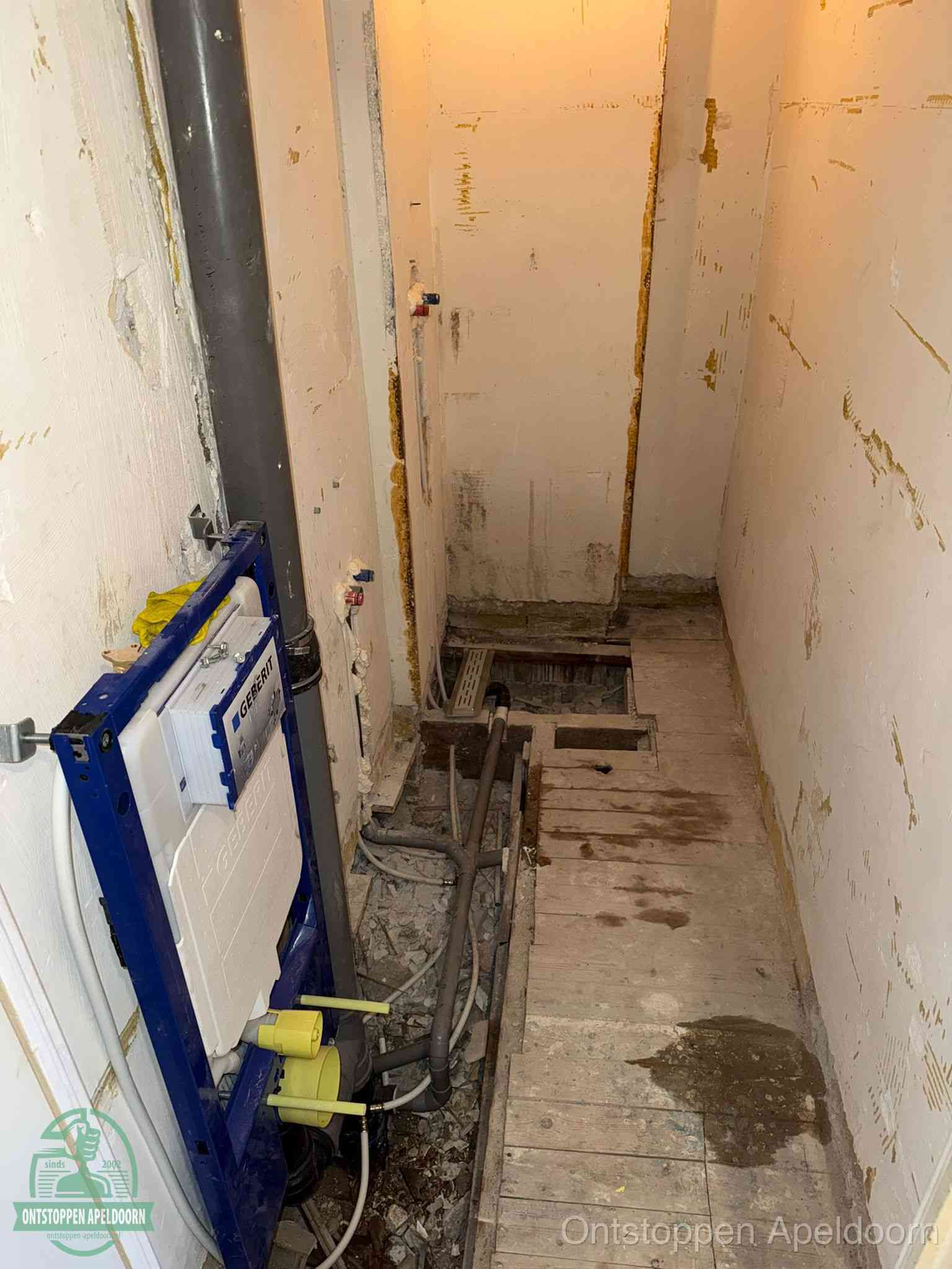 Een opgebroken toiletruimte tijdens renovatie met een Geberit inbouwreservoir en blootliggende oude afvoerleidingen, typisch voor oudere woningen in Apeldoorn